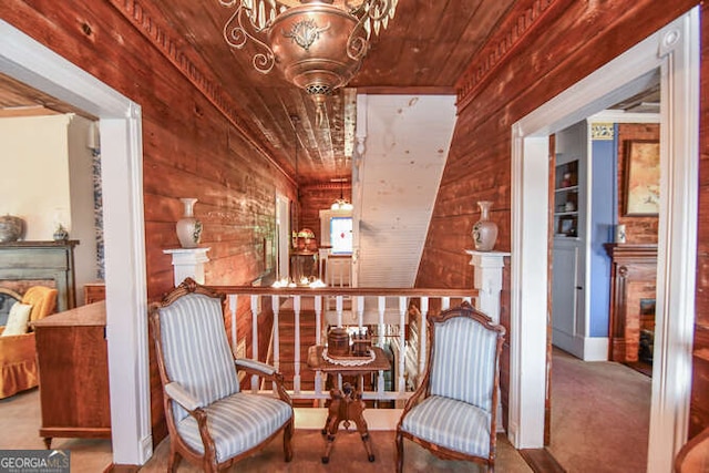 living area featuring an inviting chandelier, wood ceiling, wood walls, and carpet