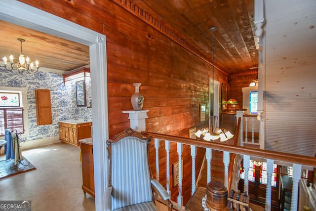 hallway with a notable chandelier, a wealth of natural light, and wooden ceiling