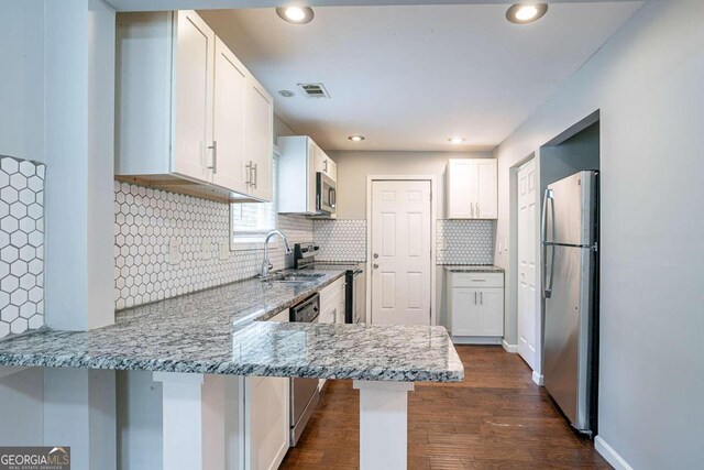 2836 Harlan Dr, Atlanta, GA 30344 - kitchen featuring white cabinets, a sink, stainless steel appliances, and a peninsula