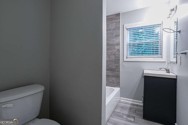 2836 Harlan Dr, Atlanta, GA 30344 - bathroom featuring vanity, a bathing tub, toilet, wood finish floors, and baseboards