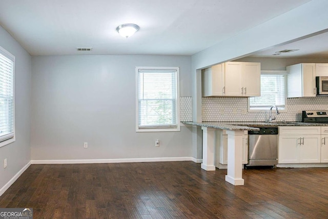 2836 Harlan Dr, Atlanta, GA 30344 - kitchen featuring decorative backsplash, visible vents, baseboards, stainless steel appliances, and dark wood-style floors
