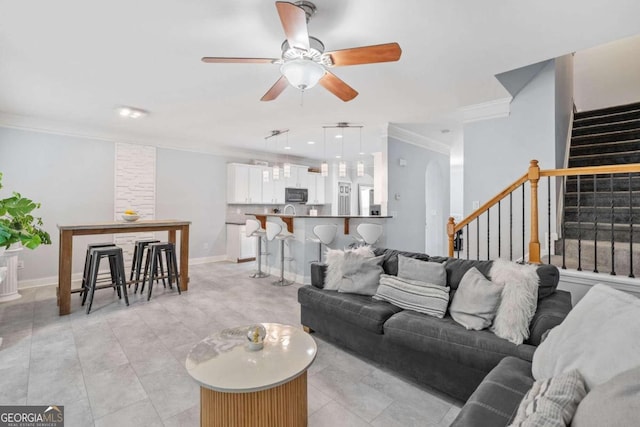 tiled living room featuring ceiling fan and crown molding