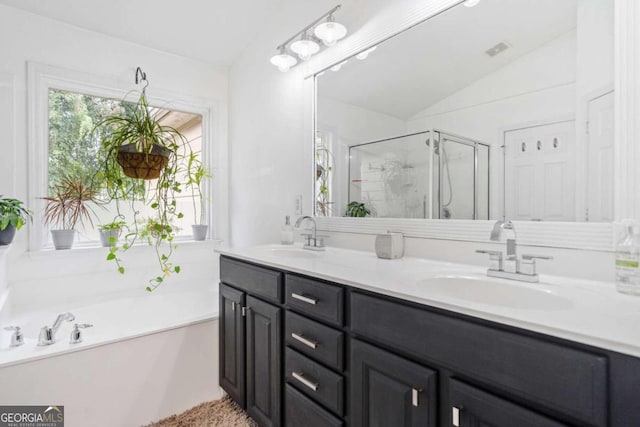 bathroom featuring vanity, shower with separate bathtub, and vaulted ceiling