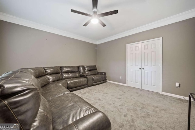 carpeted home theater featuring ornamental molding and ceiling fan