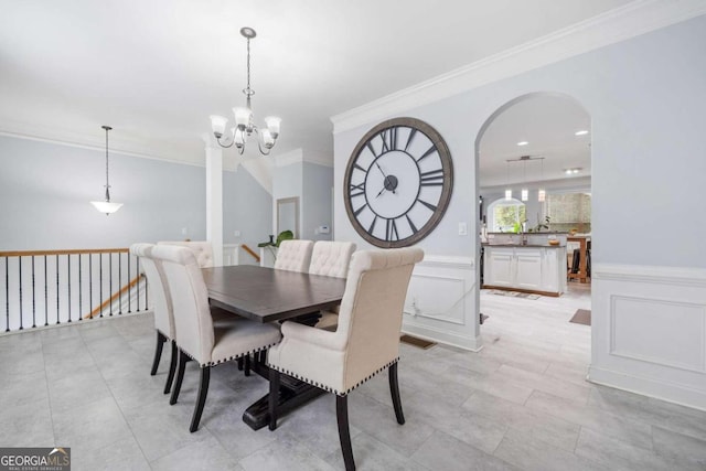 dining space with a chandelier and crown molding