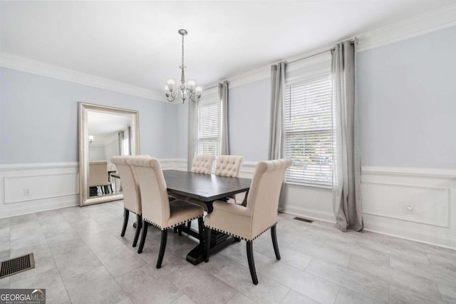 dining area with an inviting chandelier and ornamental molding