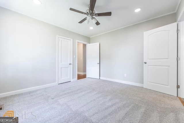 unfurnished bedroom featuring ceiling fan, carpet floors, and ornamental molding