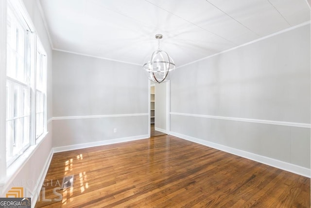 unfurnished room featuring hardwood / wood-style floors, a chandelier, and a wealth of natural light