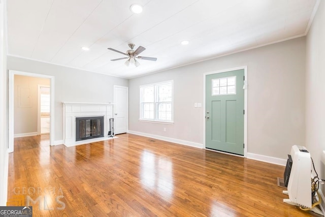 unfurnished living room featuring crown molding, ceiling fan, and light hardwood / wood-style flooring