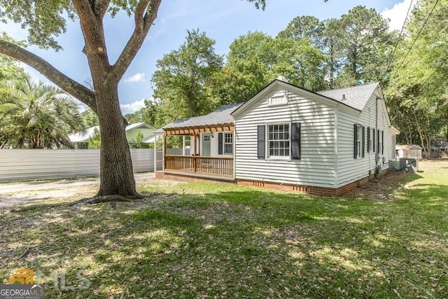 rear view of property with a yard and central air condition unit