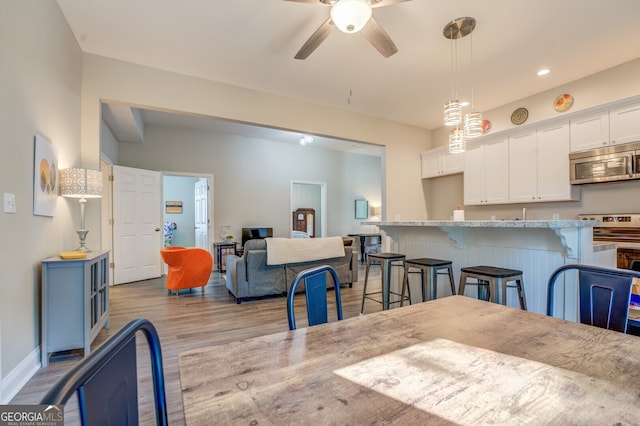 dining area with ceiling fan and light hardwood / wood-style flooring