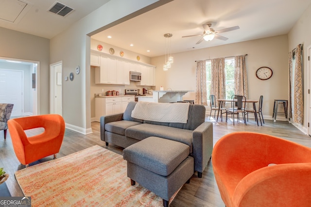 living room featuring light wood-type flooring and ceiling fan