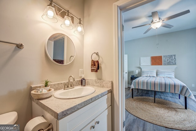 bathroom featuring ceiling fan, vanity, hardwood / wood-style floors, and toilet