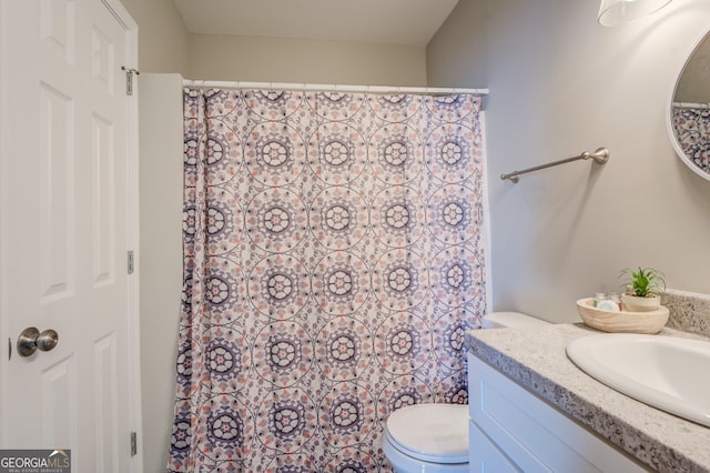 bathroom featuring a shower with shower curtain, vanity, and toilet