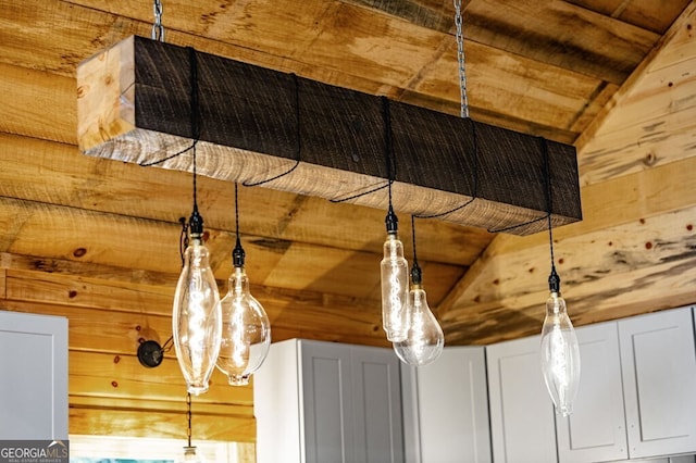 details featuring wooden walls, wooden ceiling, and white cabinetry