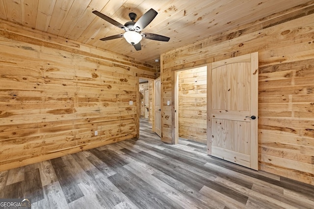 interior space featuring ceiling fan, wooden walls, dark wood-type flooring, and wood ceiling