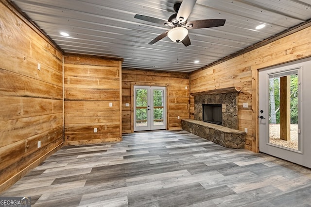 unfurnished living room featuring wood-type flooring, ceiling fan, french doors, and plenty of natural light