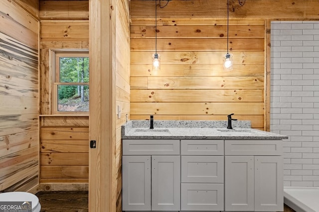 bathroom featuring wood walls, toilet, and vanity