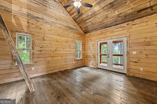 unfurnished room with french doors, wooden walls, ceiling fan, and a healthy amount of sunlight