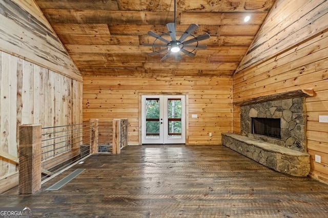 unfurnished living room with wooden walls, lofted ceiling, ceiling fan, and dark hardwood / wood-style flooring