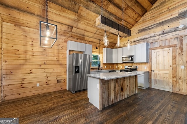 kitchen with lofted ceiling with beams, a center island, white cabinetry, appliances with stainless steel finishes, and decorative light fixtures