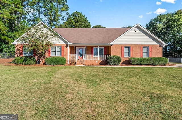 ranch-style house featuring covered porch and a front yard