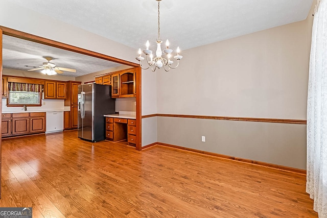 interior space with wood-type flooring, a textured ceiling, ceiling fan with notable chandelier, and sink