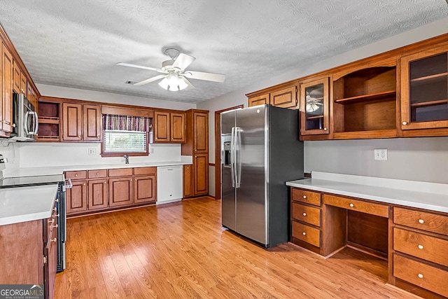 kitchen with ceiling fan, a textured ceiling, appliances with stainless steel finishes, and light hardwood / wood-style flooring