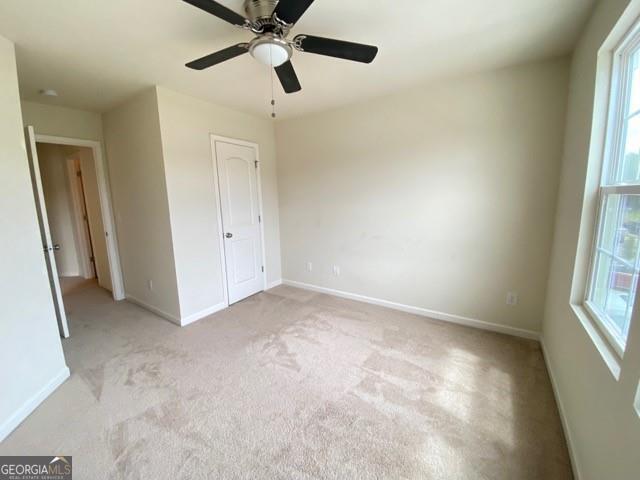 unfurnished bedroom with light carpet and ceiling fan