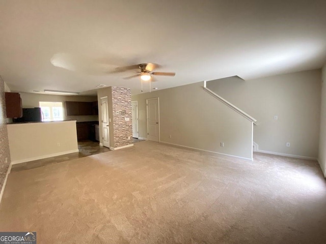 unfurnished living room featuring ceiling fan and carpet floors