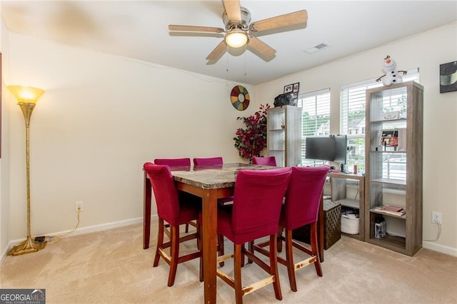 carpeted dining space with ceiling fan