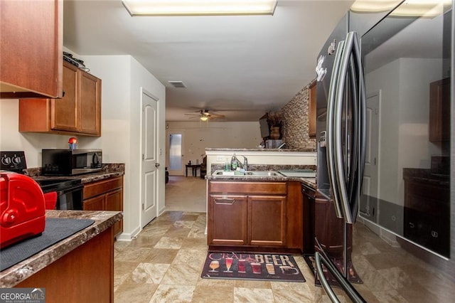 kitchen with kitchen peninsula, sink, ceiling fan, and stainless steel appliances