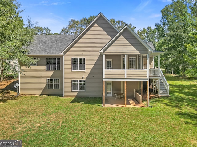 rear view of property featuring a lawn and a patio area