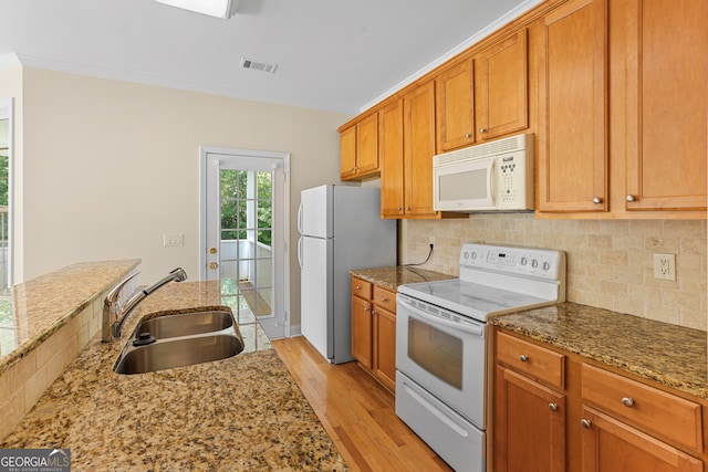 kitchen with light hardwood / wood-style floors, sink, ornamental molding, white appliances, and light stone countertops