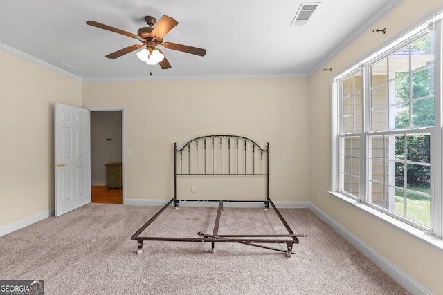 carpeted bedroom with ornamental molding and ceiling fan