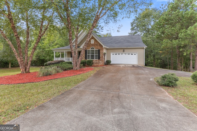 view of front of property featuring covered porch, a front yard, and a garage