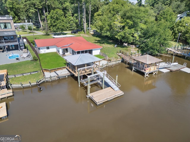 view of dock with a yard and a water view