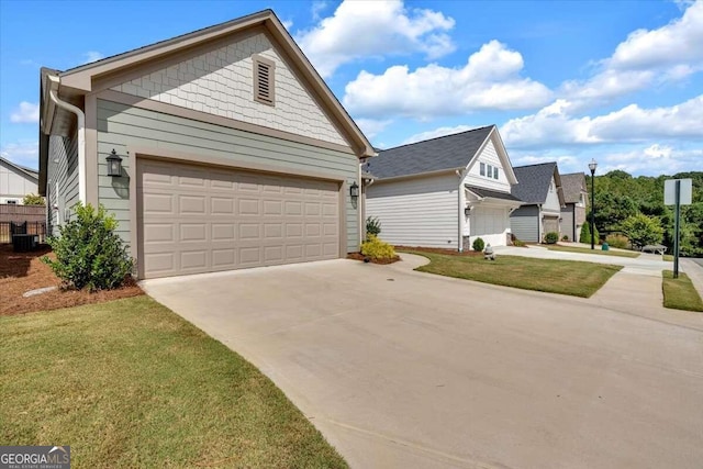 view of front of home featuring central AC, a front yard, and a garage