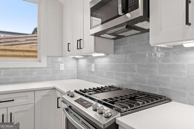 kitchen featuring appliances with stainless steel finishes, white cabinetry, and tasteful backsplash