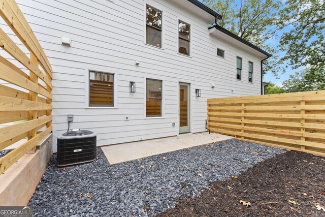 rear view of house with cooling unit and a patio area