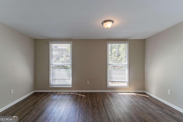 empty room featuring dark hardwood / wood-style flooring and plenty of natural light