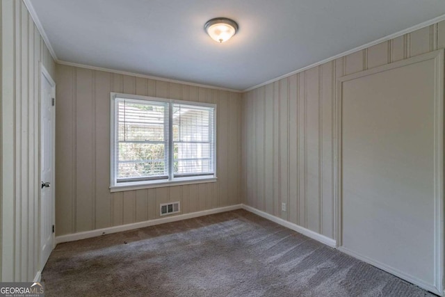 empty room with ornamental molding and carpet floors