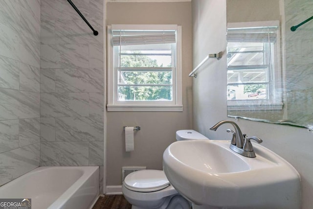 full bathroom featuring hardwood / wood-style floors, sink, tiled shower / bath combo, and toilet