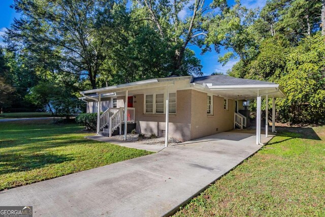 view of front facade featuring a front yard, covered porch, and a carport