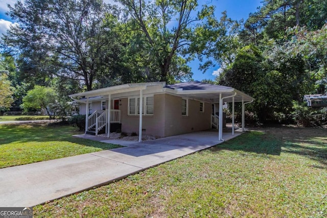 back of house with a lawn, covered porch, and a carport