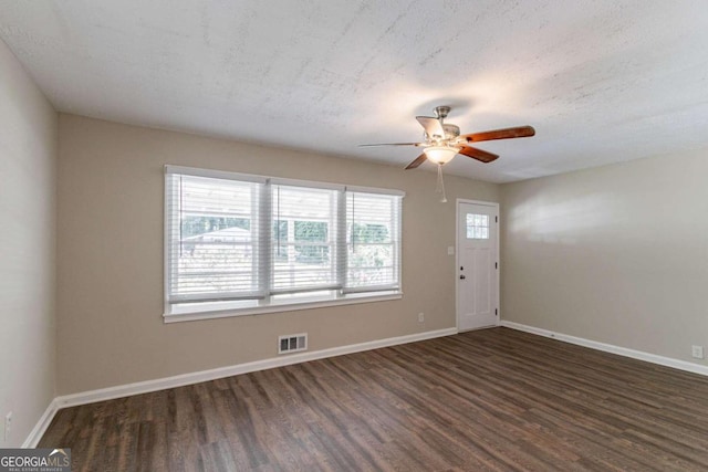 entrance foyer with a textured ceiling, ceiling fan, plenty of natural light, and dark hardwood / wood-style flooring