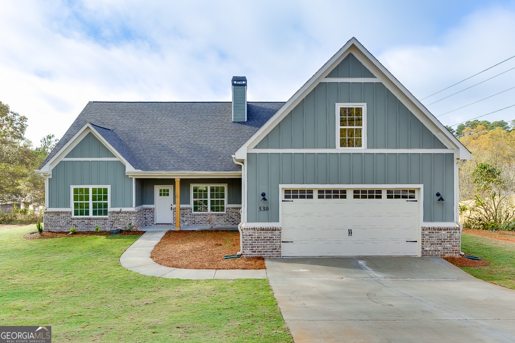 craftsman inspired home featuring a garage and a front yard