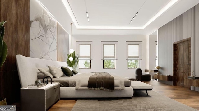 bedroom featuring a tray ceiling and light hardwood / wood-style flooring