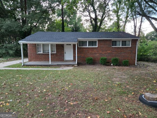 ranch-style home with a front lawn and covered porch