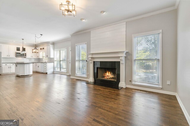 unfurnished living room featuring crown molding, dark wood-type flooring, and a premium fireplace